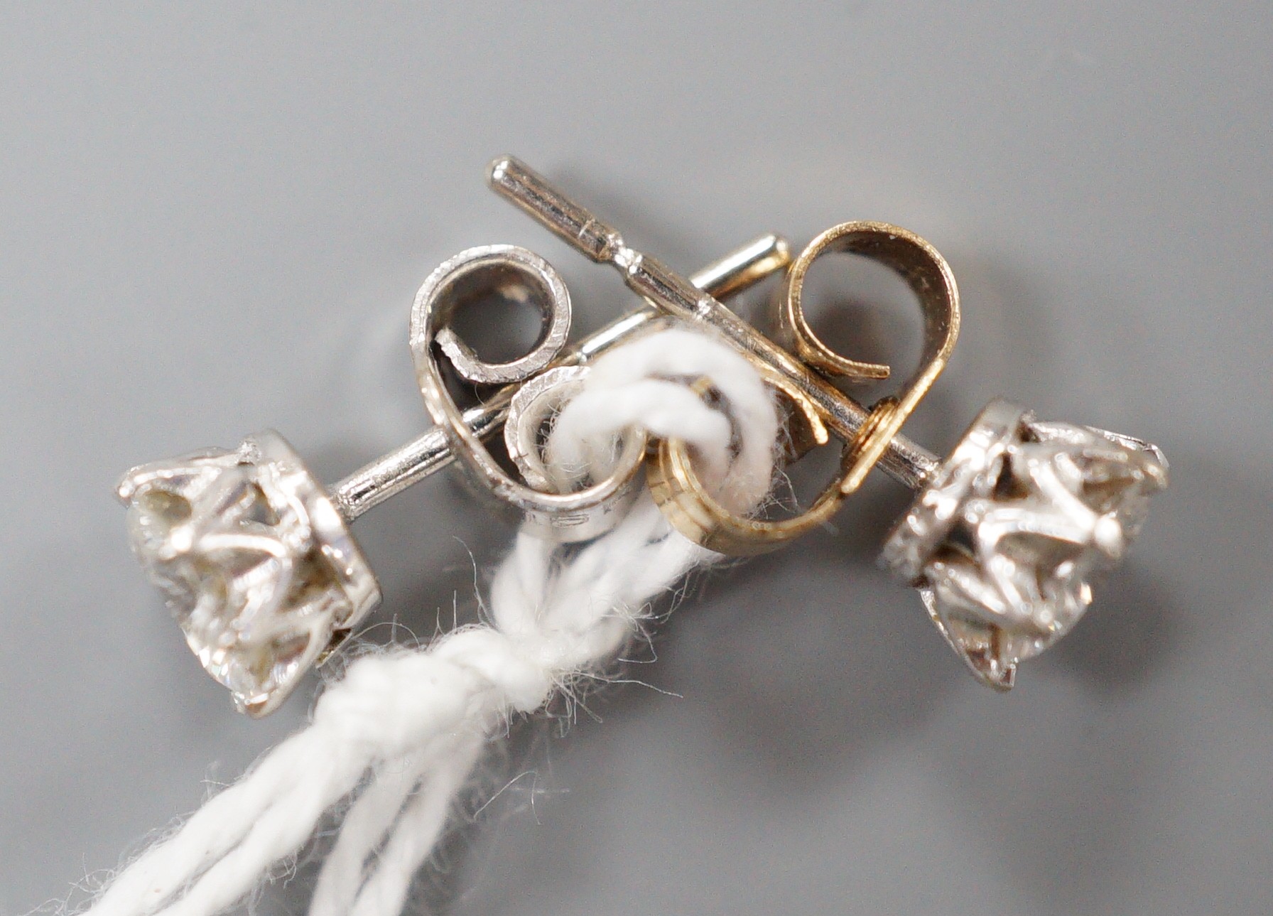 A modern pair of 18k white metal and solitaire diamond set ear studs (butterflies differ), gross weight 1.4 grams